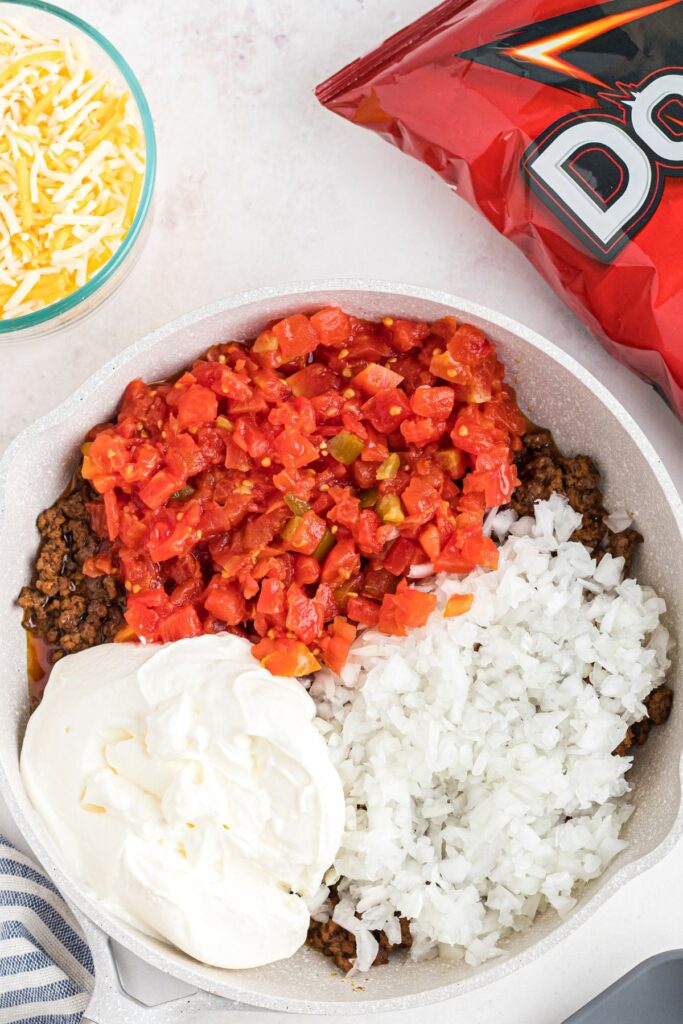 Ground beef in a medium skilled with chopped onions, sour cream, and tomatoes. 