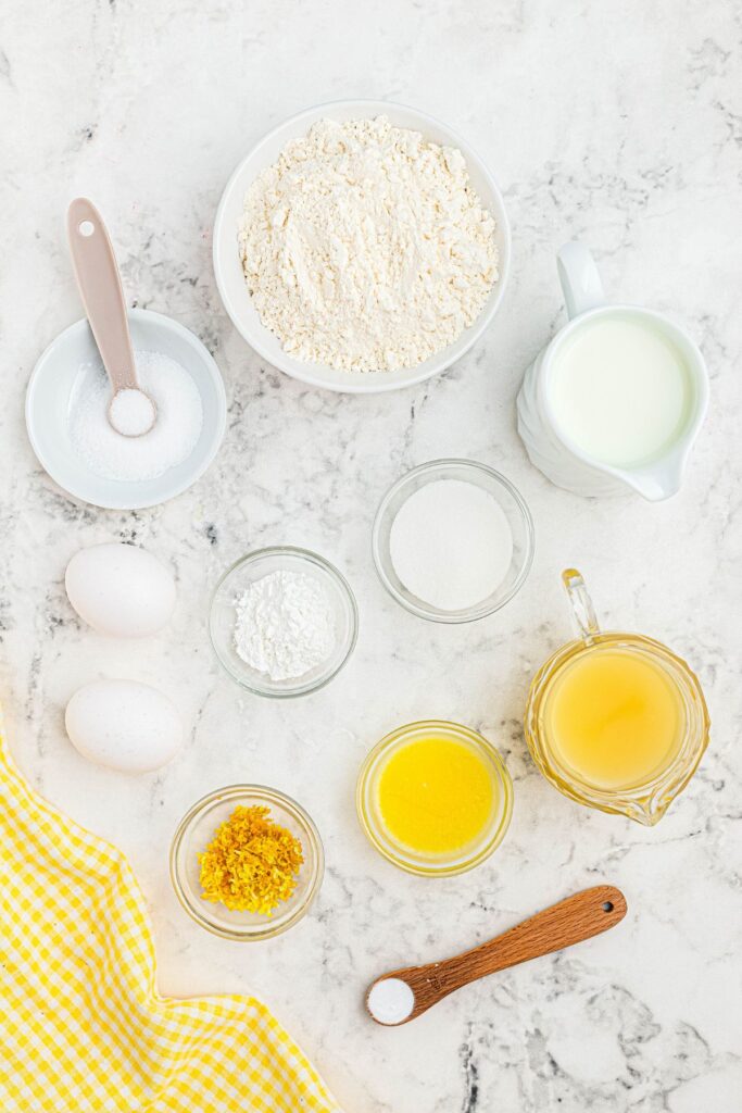 Ingredients measured in small bowls on a white marble table. 