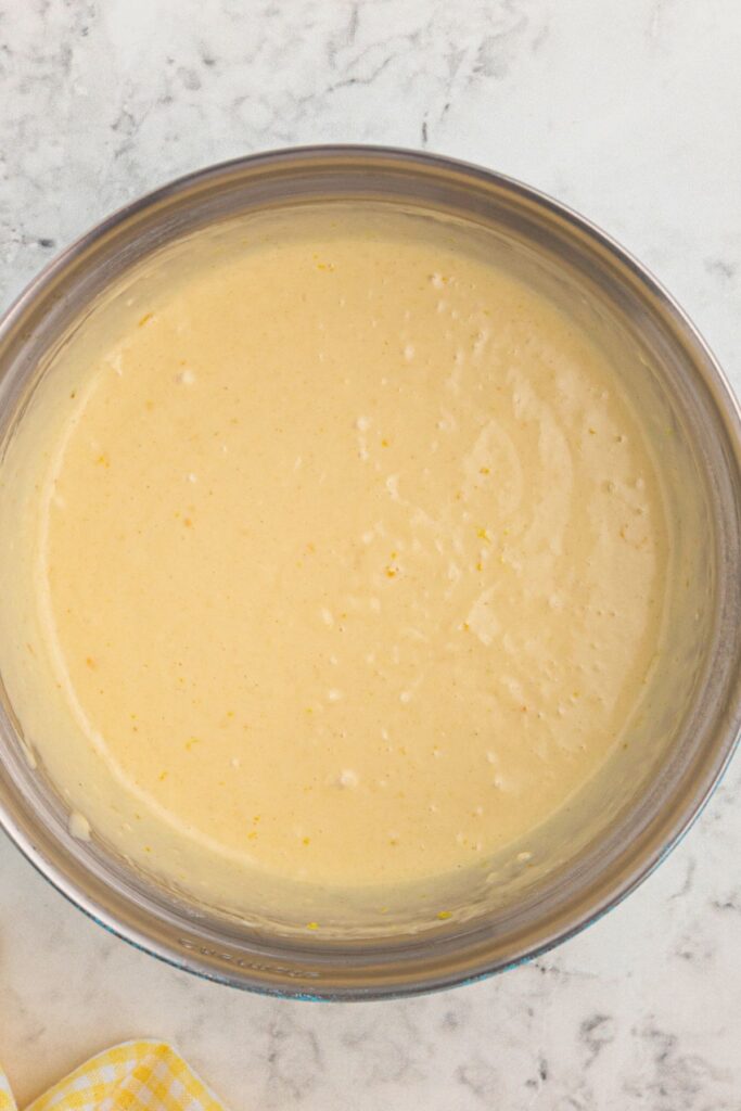 Pancake batter mixed in a large clear glass bowl. 