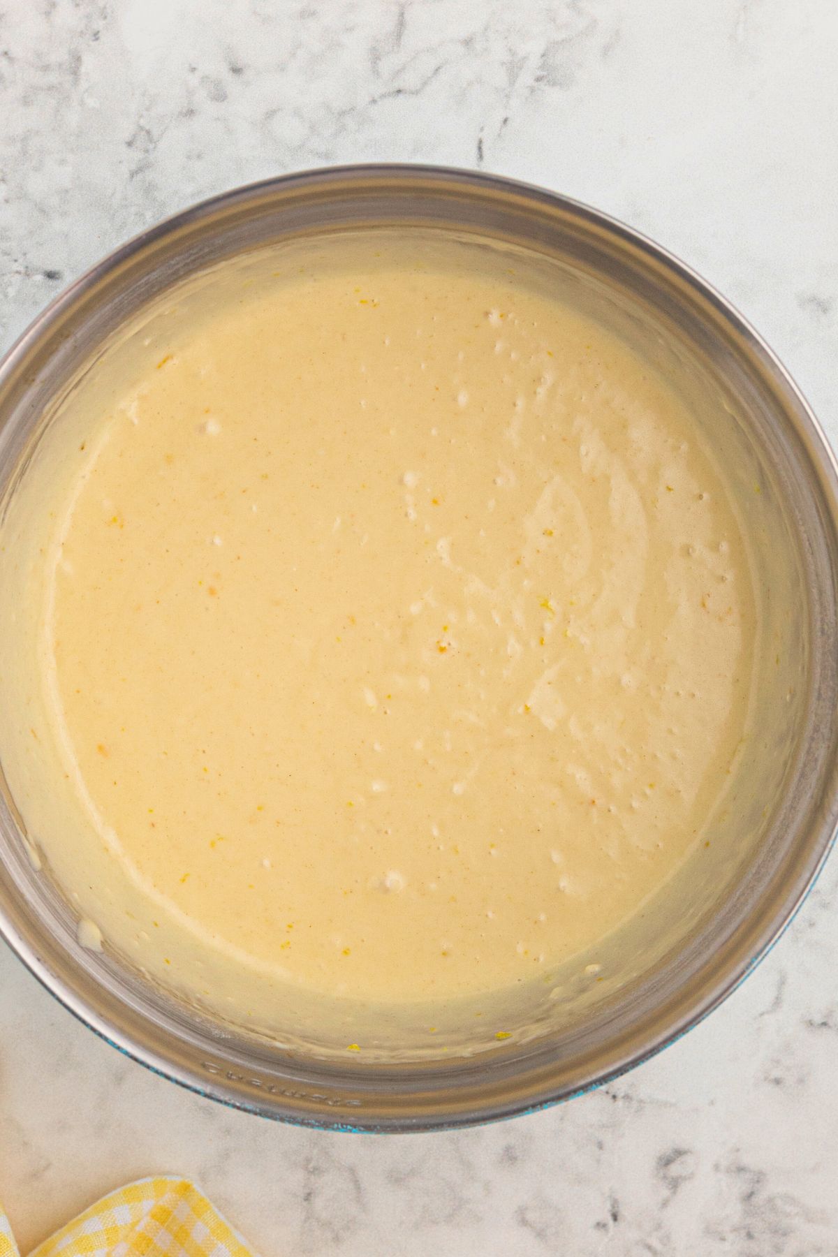 Pancake batter in a large clear glass bowl.