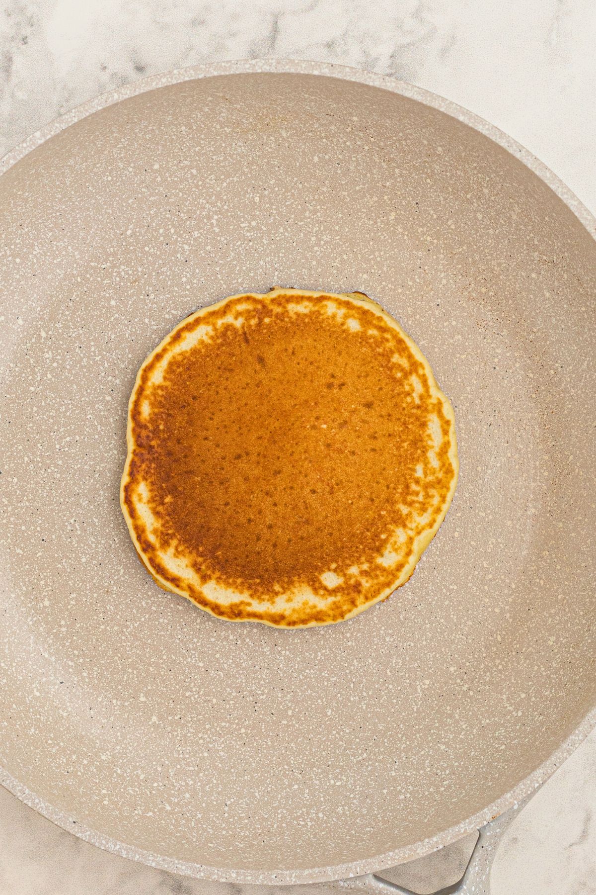 Golden pancake cooked in a skillet.