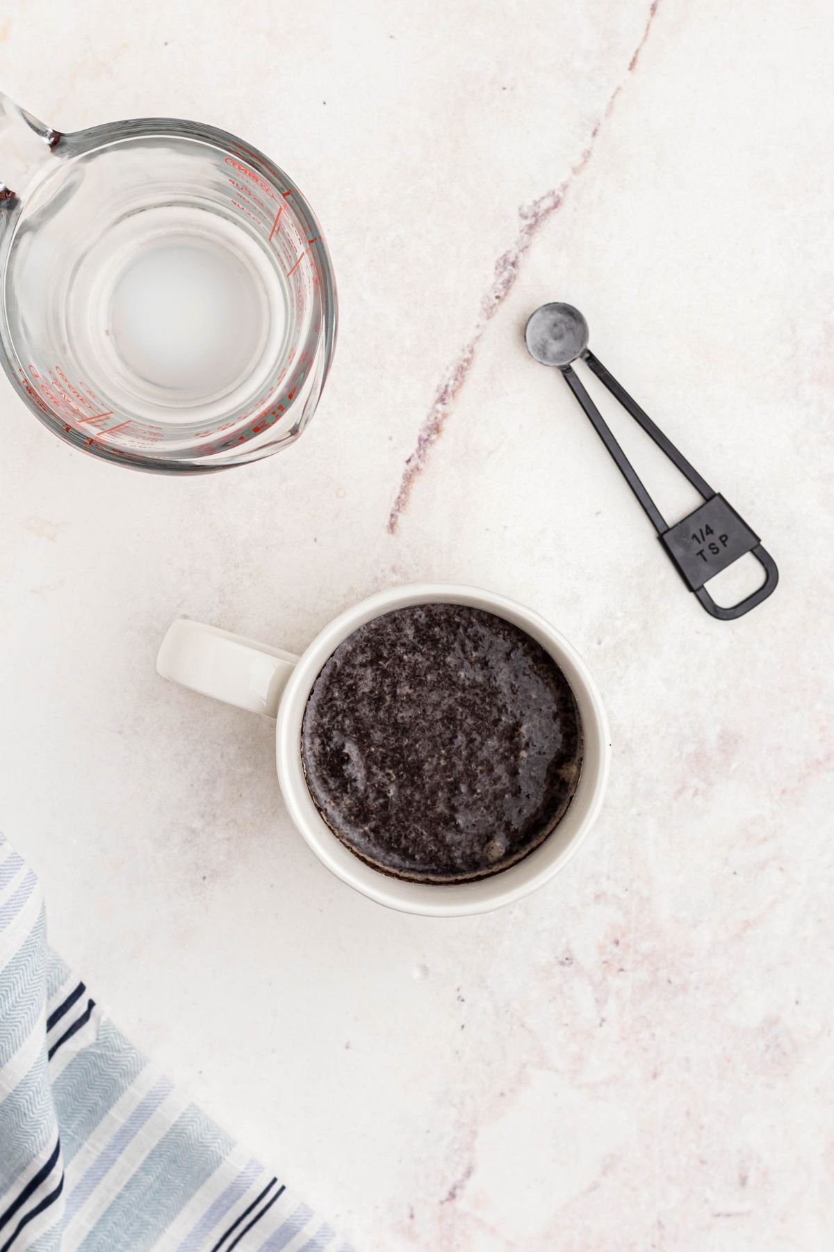 Crushed oreos, mixed with milk in a white coffee mug.