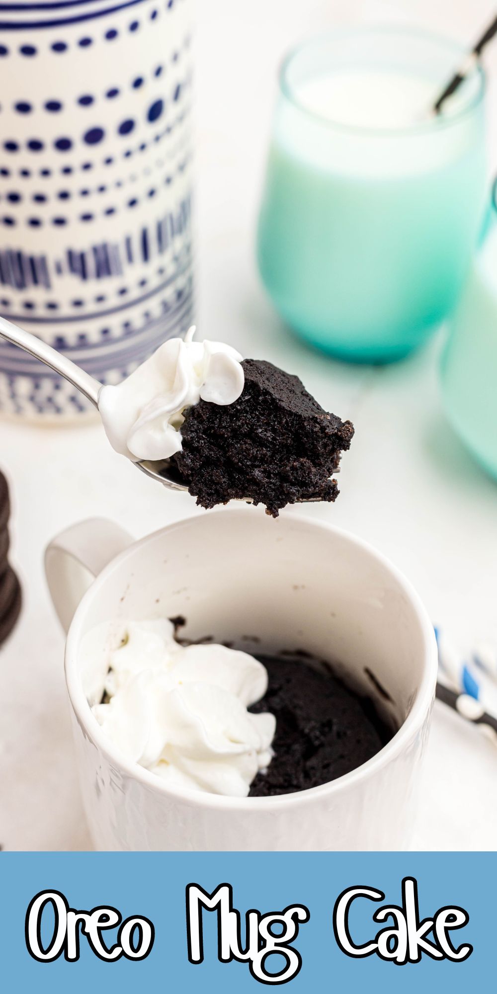 Oreo Mug Cake in a white mug in front of glasses of milk.