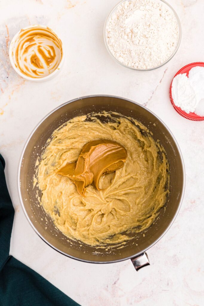 Peanut butter being added to make Cookie dough in a bowl. 