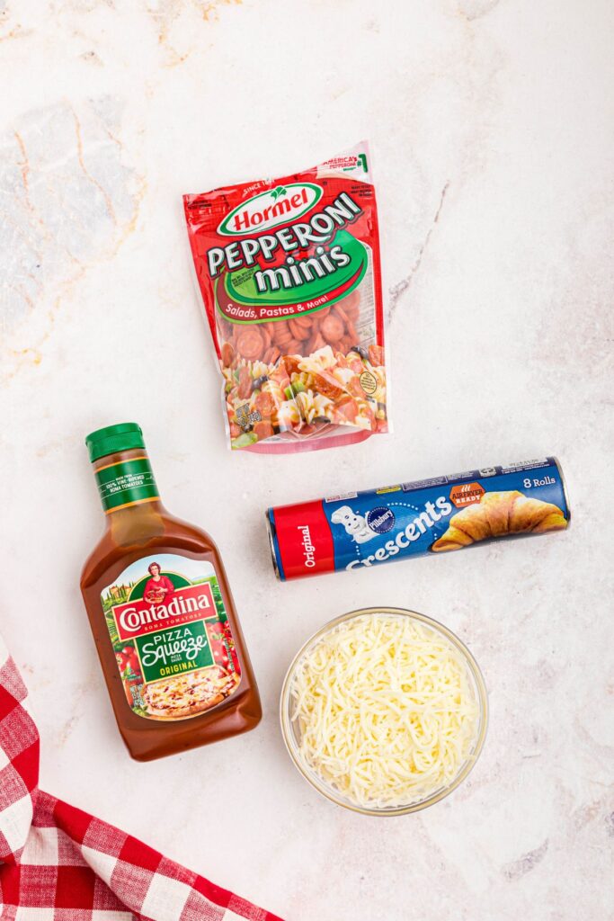 Ingredients needed to make pizza cupcakes on a marble table. 