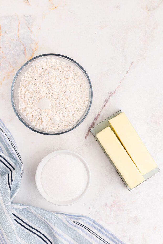 Flour, sugar, and butter measured and on a marble table. 