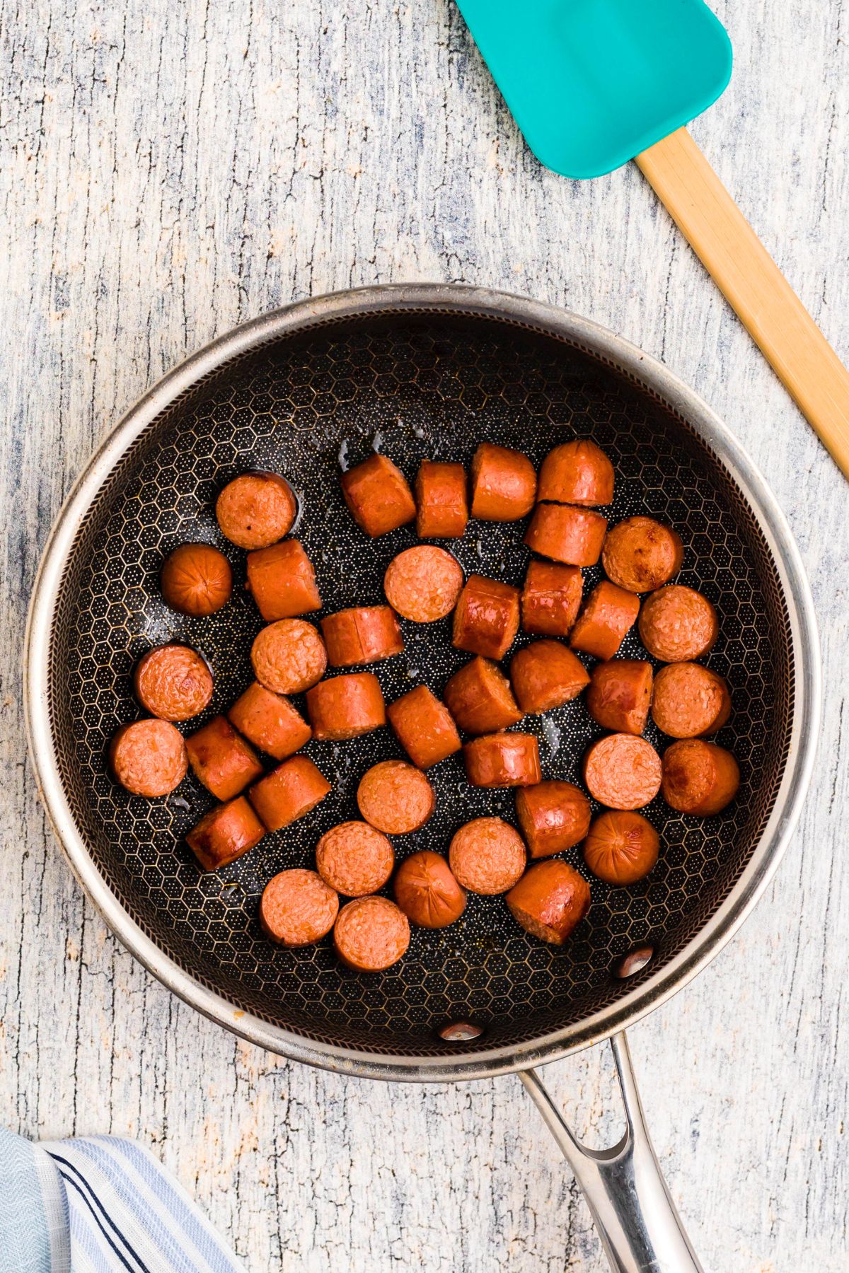 Hot dogs cut into slices, browed in a skillet. 