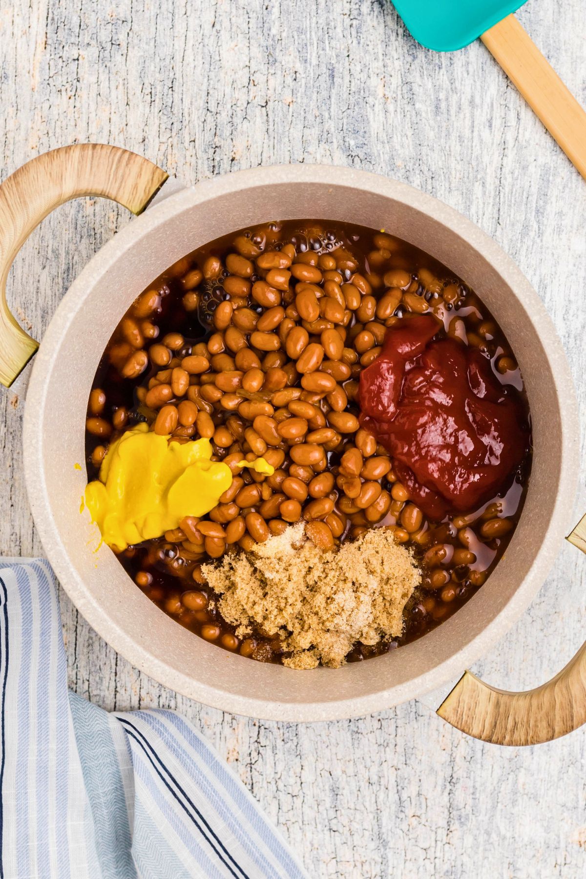 Mustard, ketchup and other ingredients being added to saucepan. 