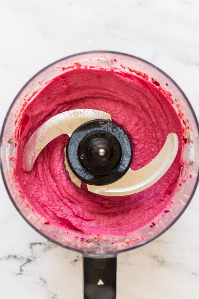 Beet hummus in a food processor after being mixed.