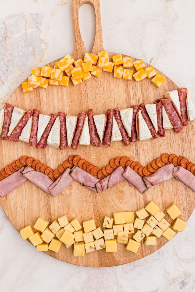 Meats and cheeses laid out on a charcuterie board.