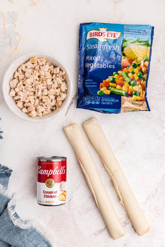 Ingredients needed to make chicken pot pie on a marble table. 