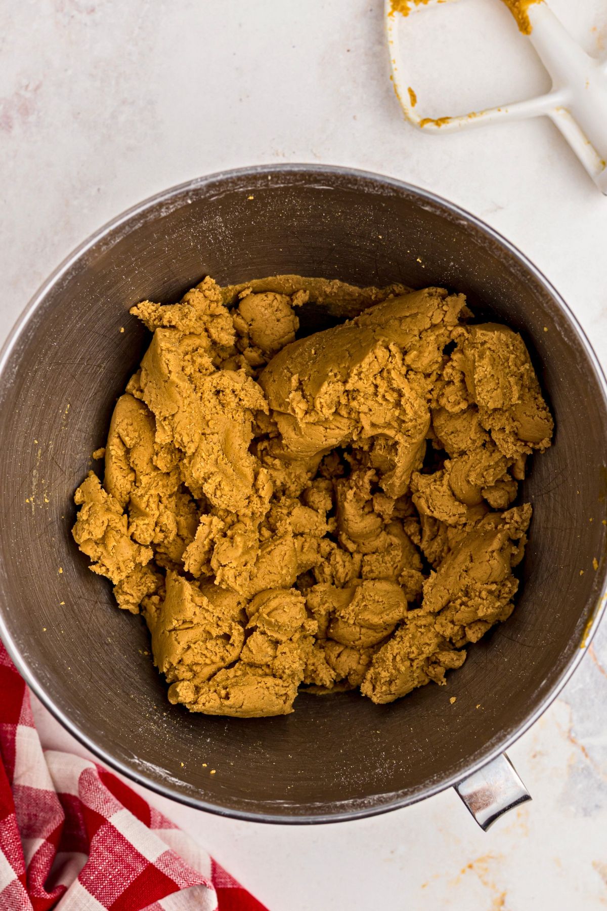 Light and fluffy gingerbread cookie dough in a silver mixing bowl. 