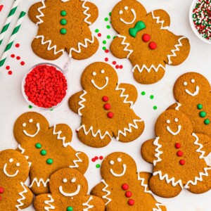 Golden brown gingerbread cookies frosted and scattered on a marble table.