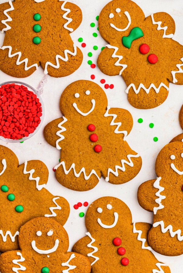 Golden brown gingerbread cookies frosted and scattered on a marble table.