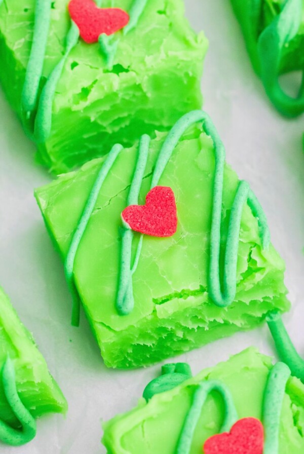 Bright green squares of fudge cut on a white table.