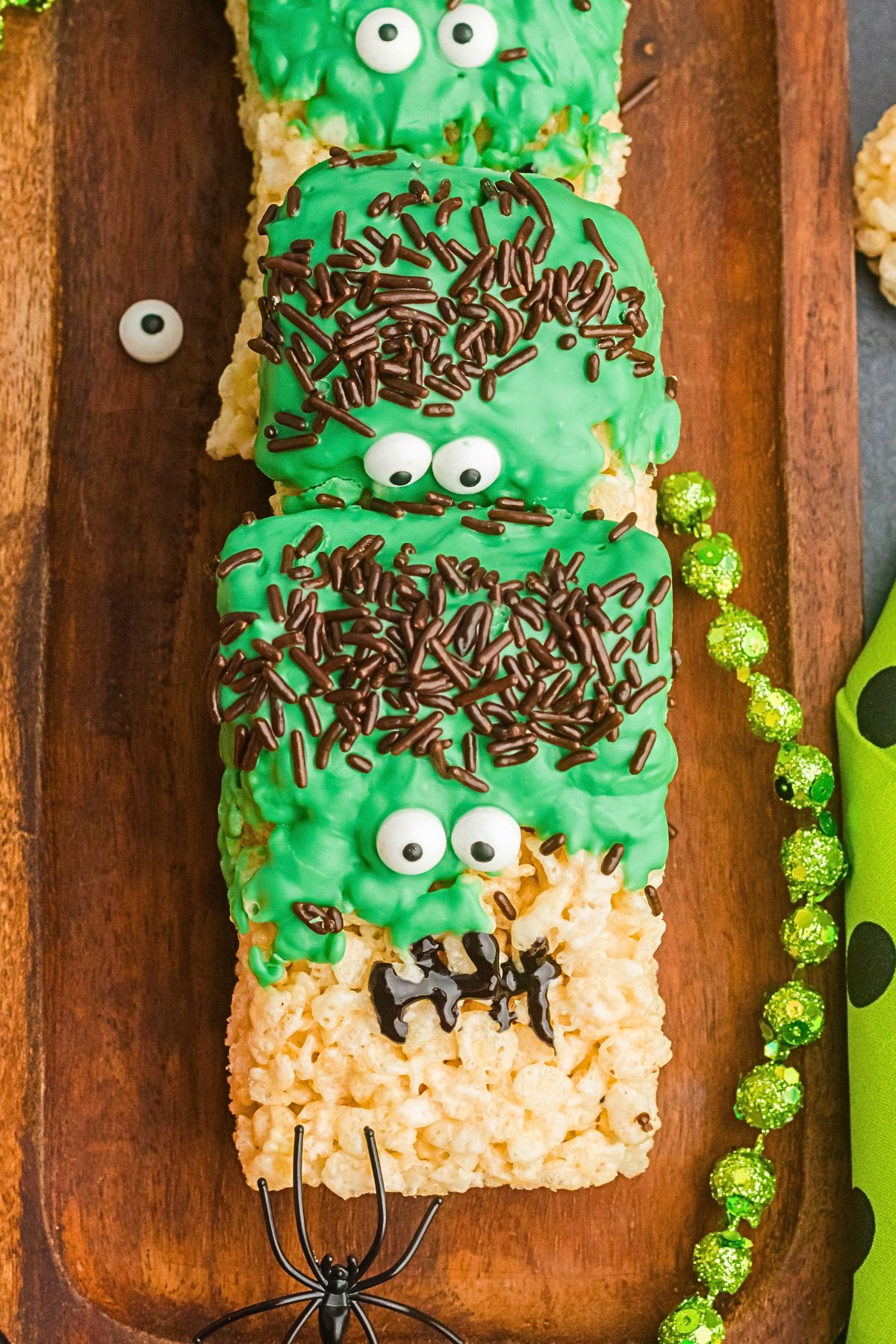 Fun Halloween rice krispies treats in the shape of Frankenstein on a wooden board. 