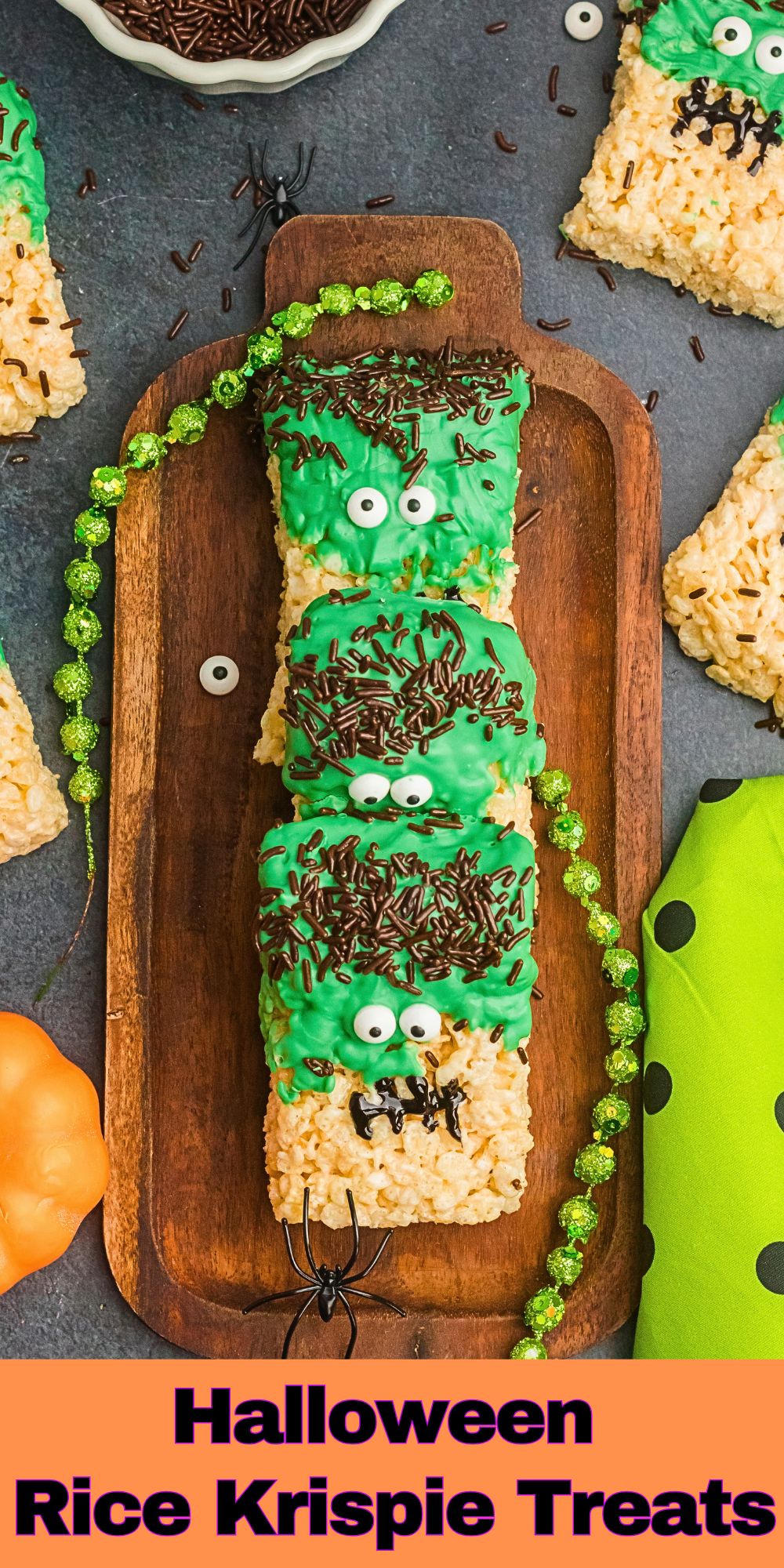 Halloween rice krispie treats on a wooden board with decorations on the table.