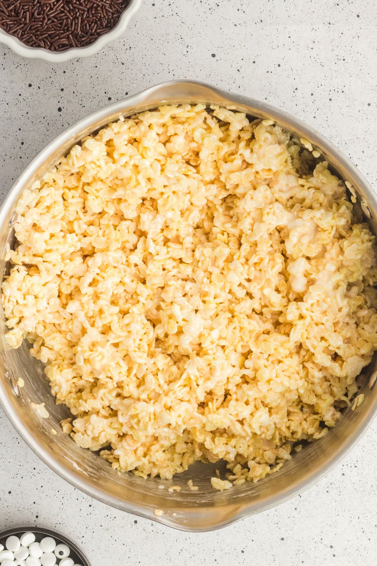 Rice krispie cereal mixed with melted butter and marshmallows in a large saucepan. 