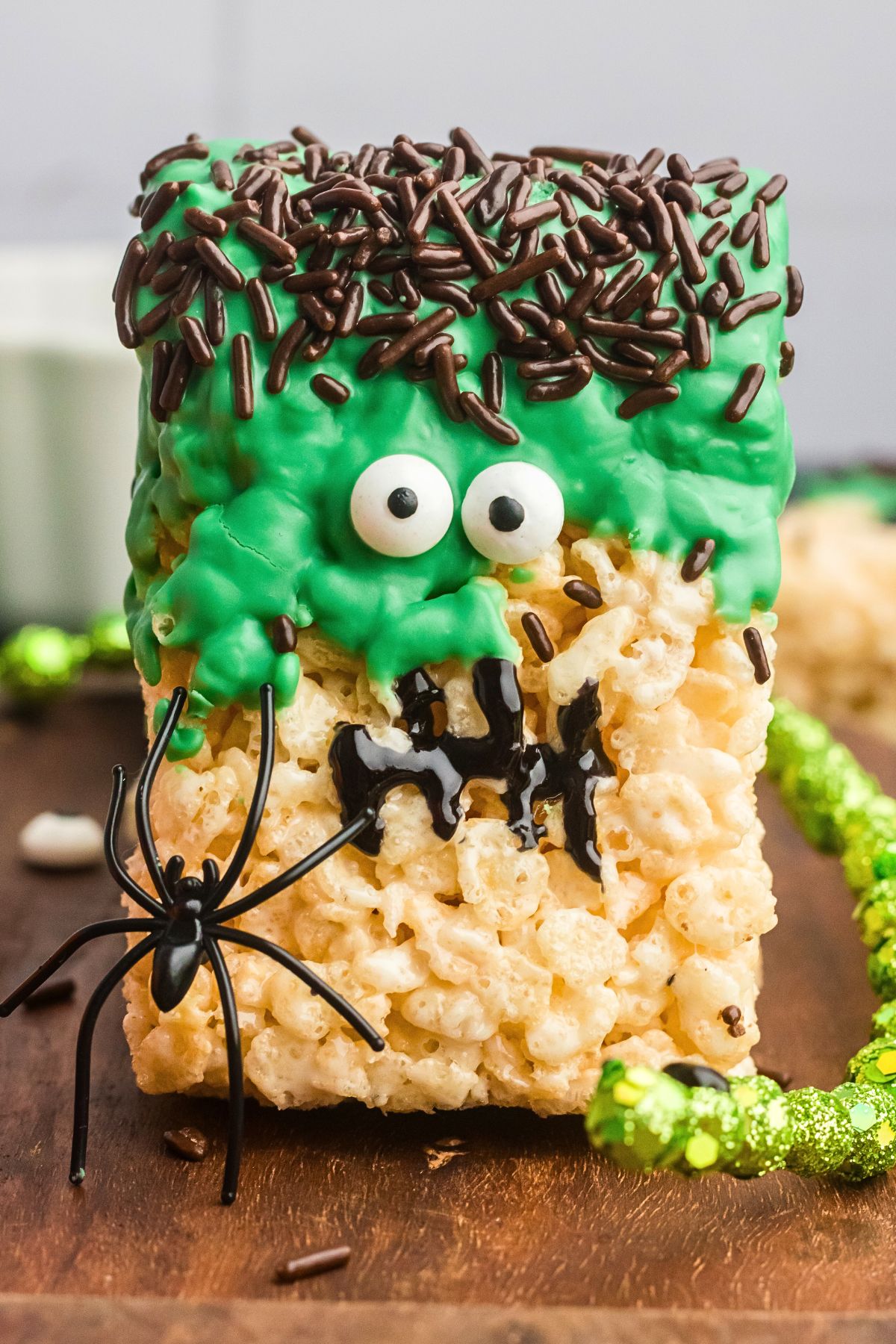 close up of Rice krispie treat decorated to look like Frankenstein on a wooden board. 