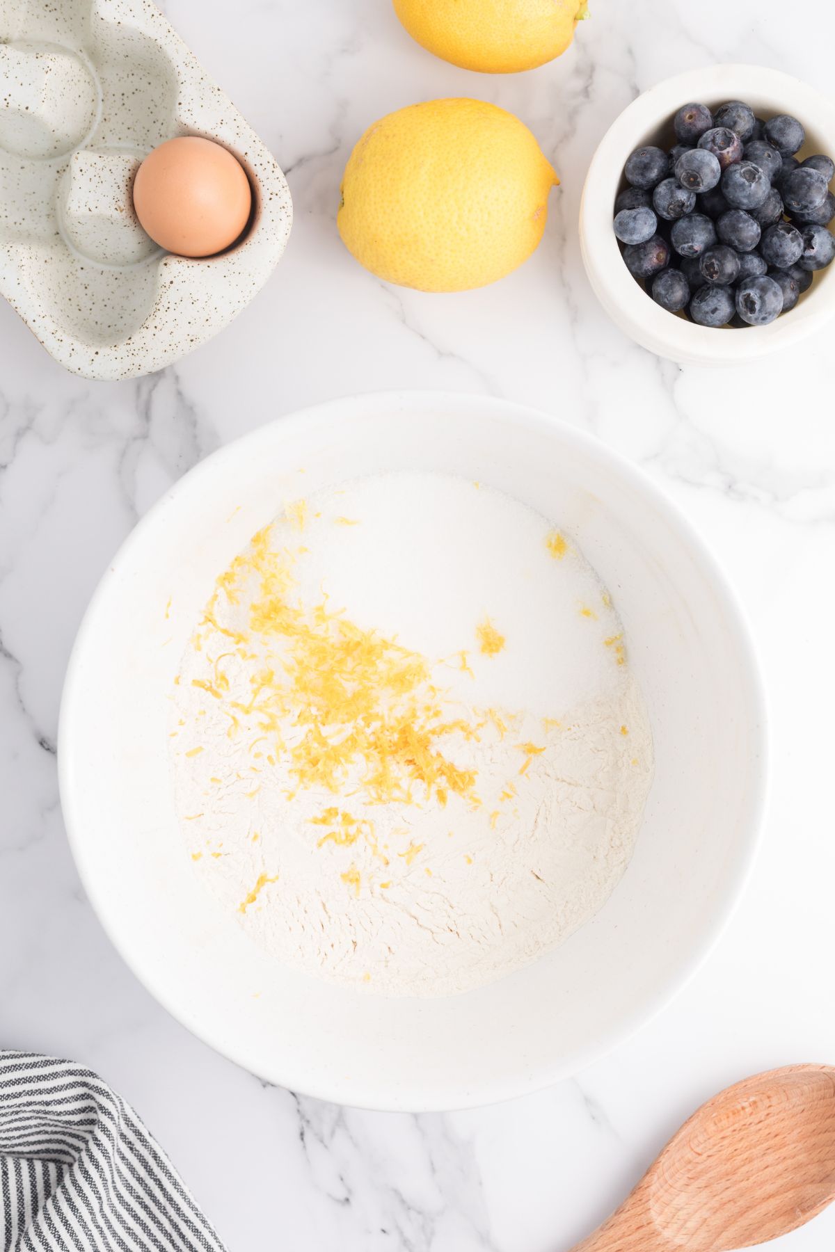 Flour and other ingredients being combined in a white bowl.