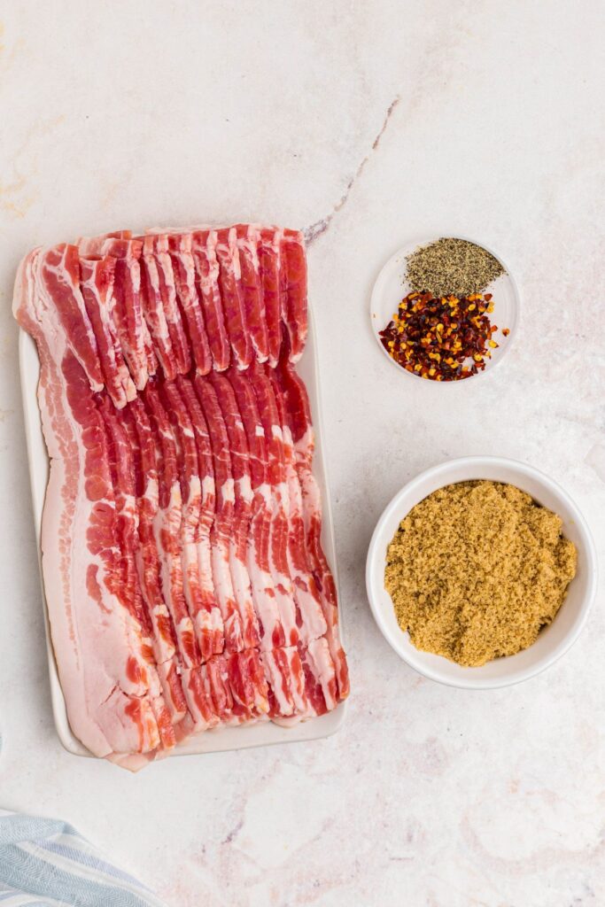 Bacon and seasonings on a marble table before cooking.