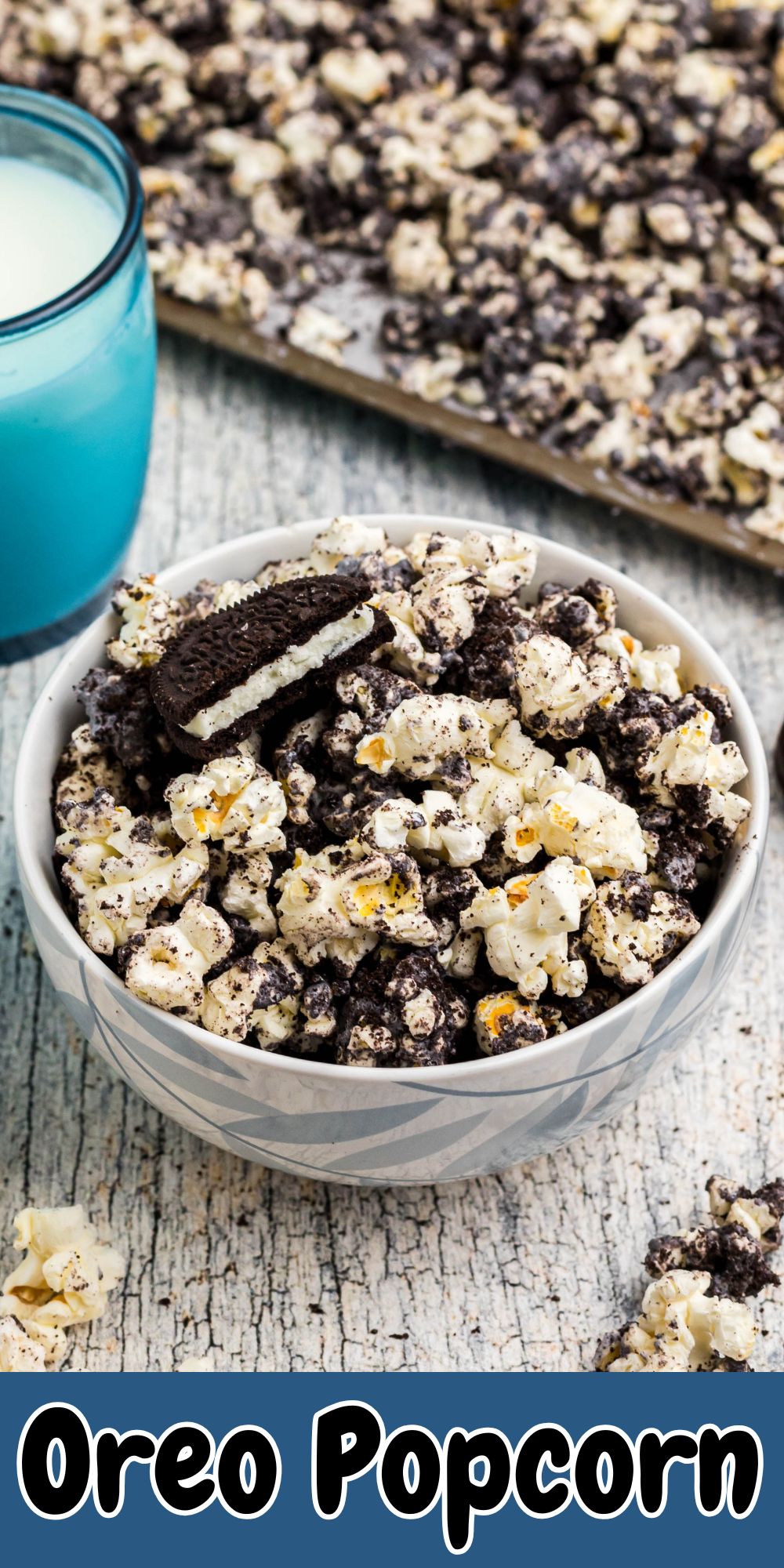 Oreo popcorn in a bowl with glasses of milk on the table with pieces of popcorn scattered.