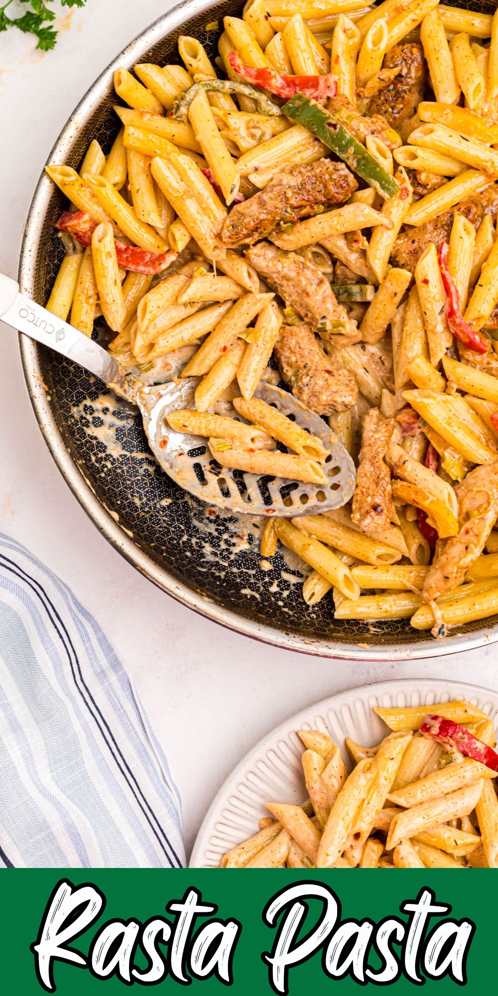 Creamy Rasta Pasta with chicken in a large skillet with a spoonful being scooped out.