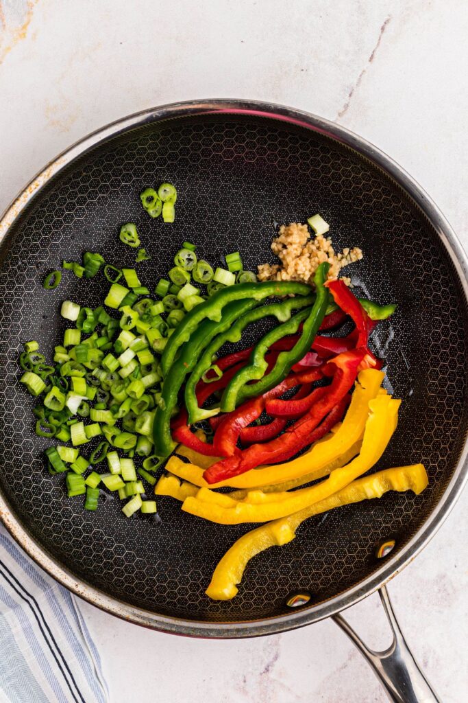 Bell pepper, onions, and garlic in a large skillet. 