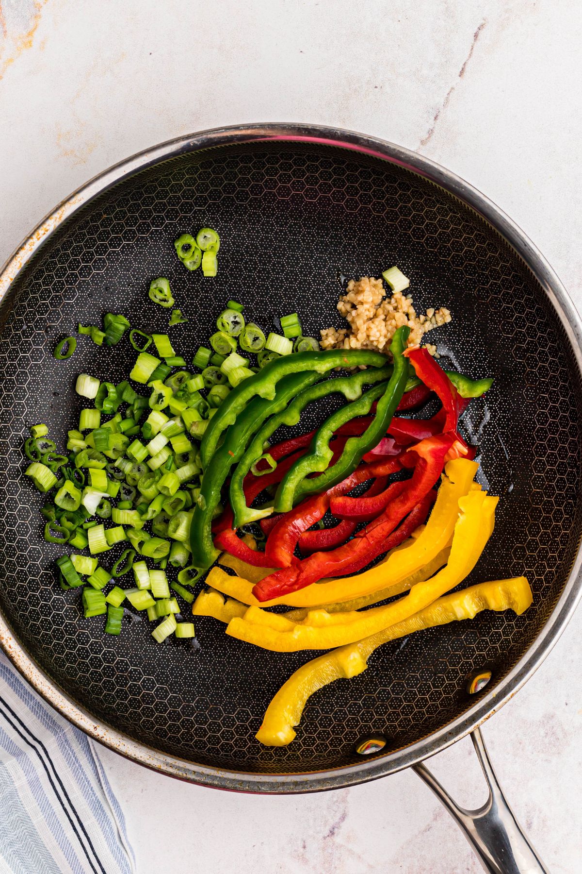 Vegetables in a large skillet before saut&eacute;ing.