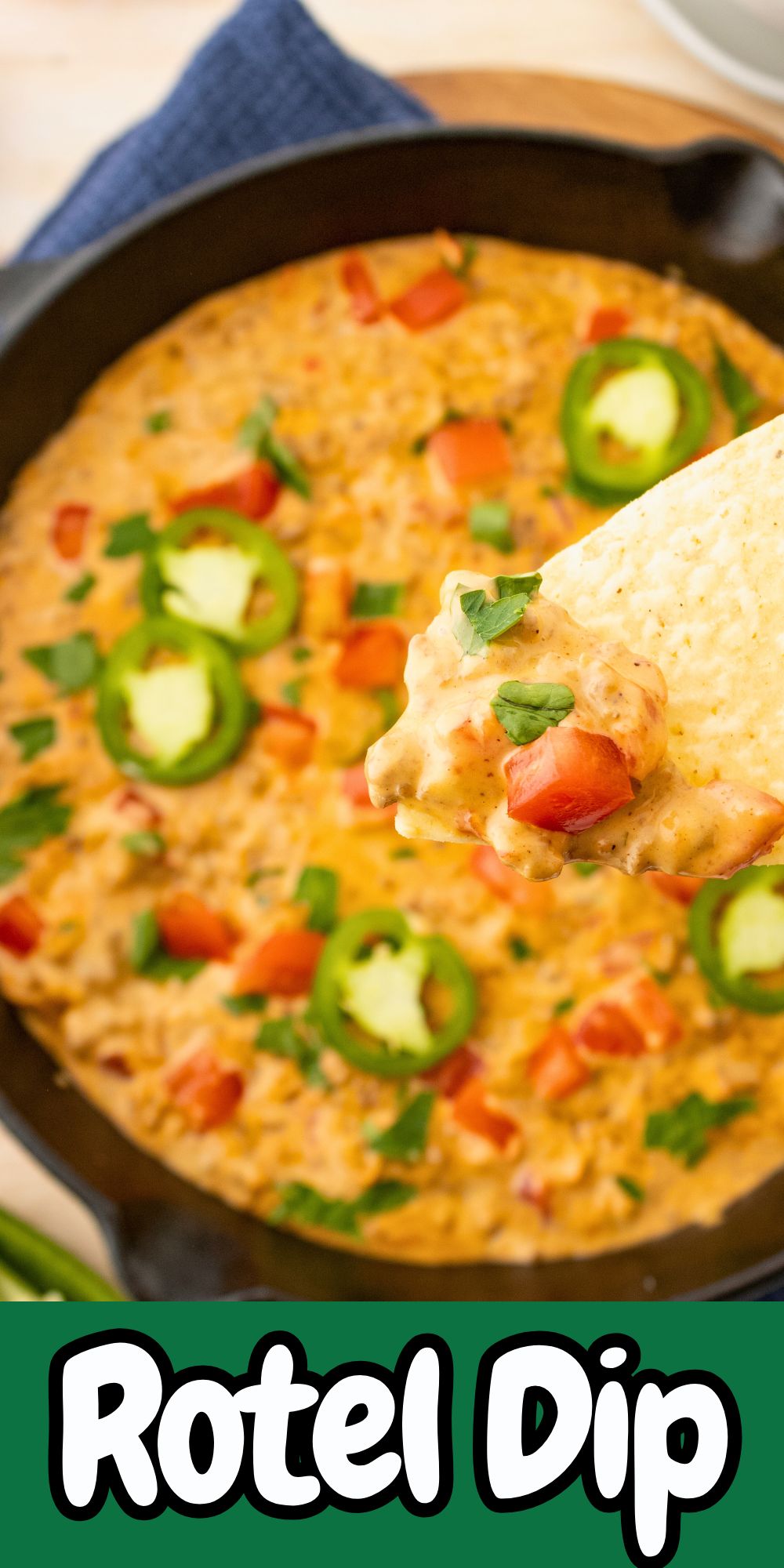 Cheesy dip in a black skillet with a tortilla chip in the center.