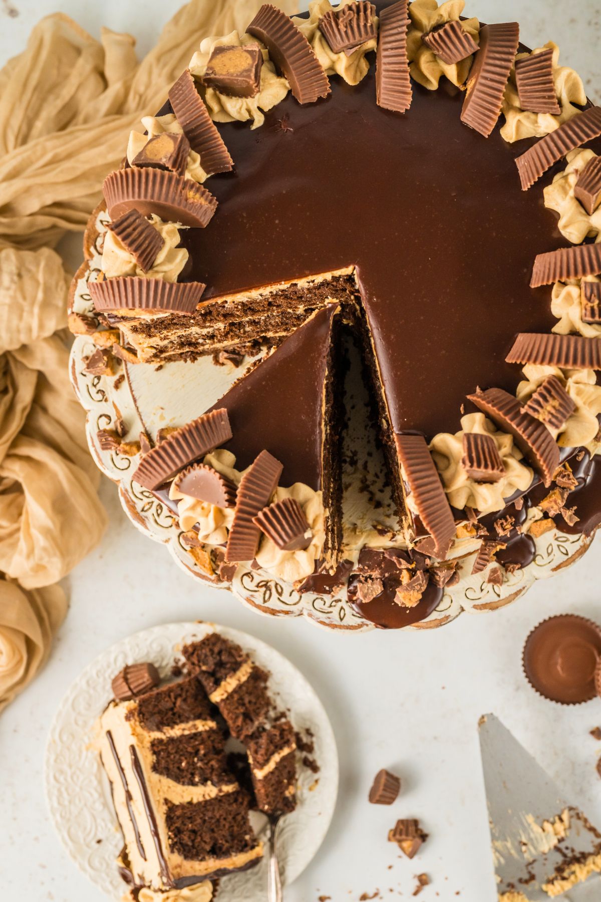 Top view of a chocolate peanut butter cake with a slice removed and served on a small plate. 