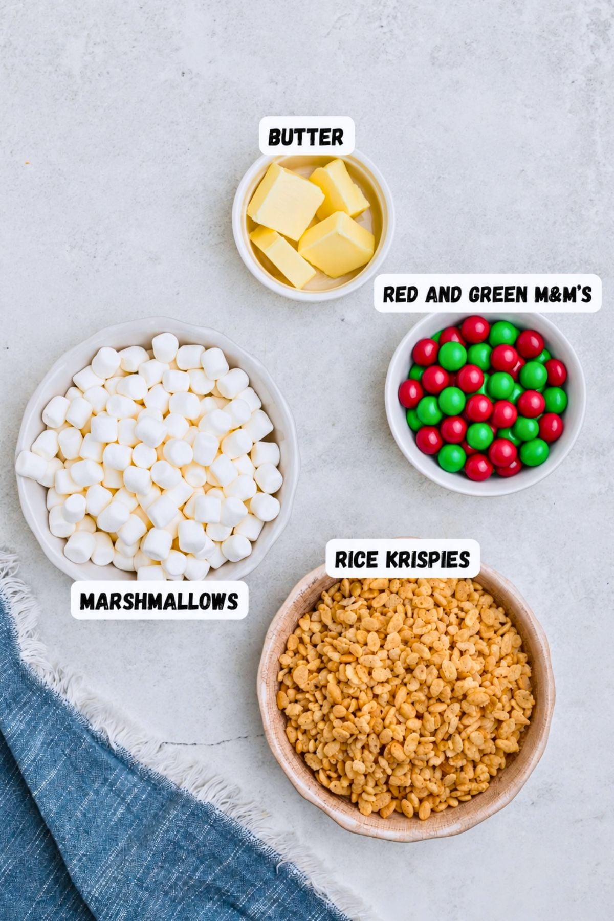 Pictures of ingredients needed to make Christmas rice krispie treats on a marble table. 