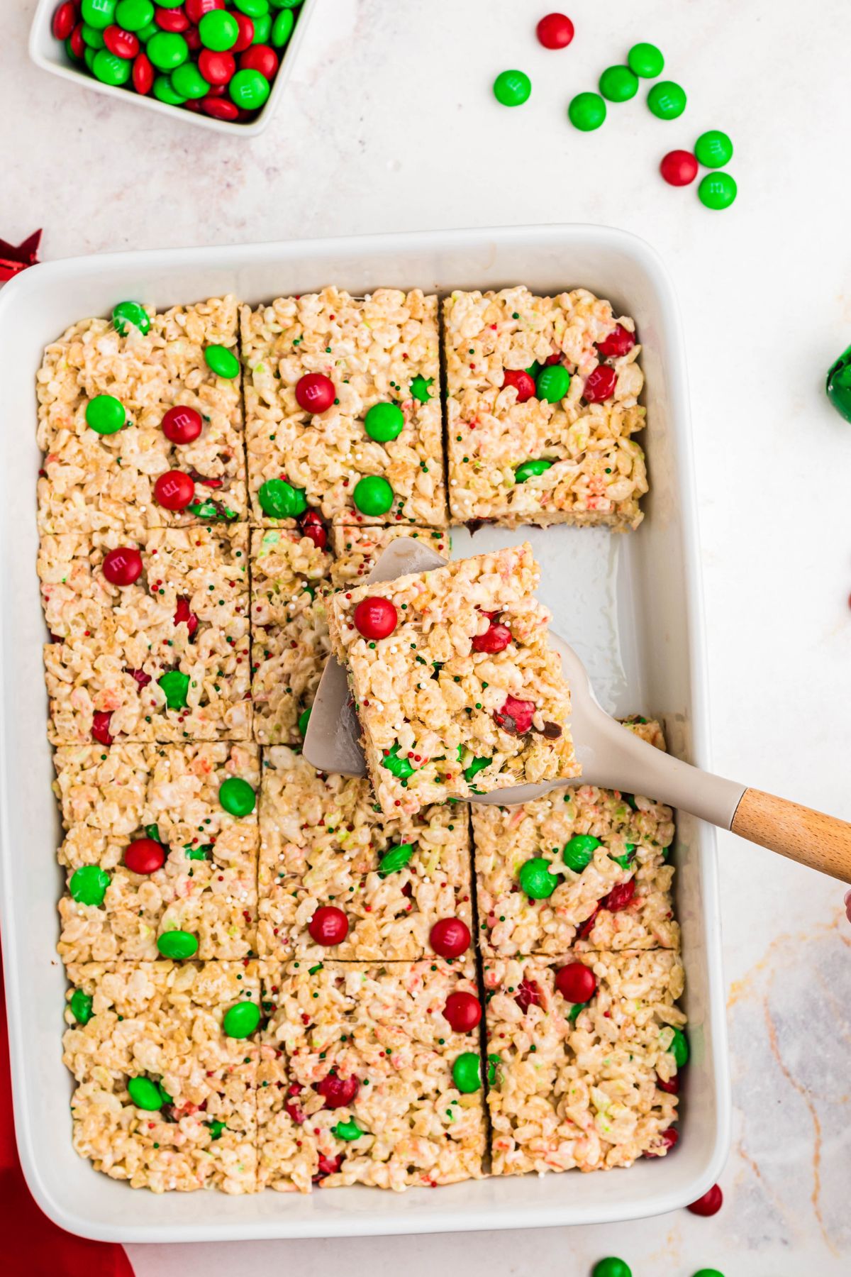 Rice krispie treats cut into squares and one being picked up with a spatula. 