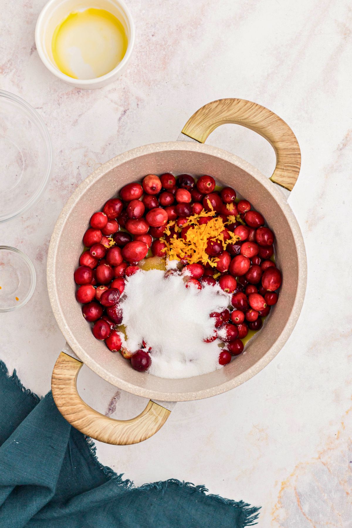 Medium saucepan with fresh cranberries, sugar, and orange juice in the saucepan. 