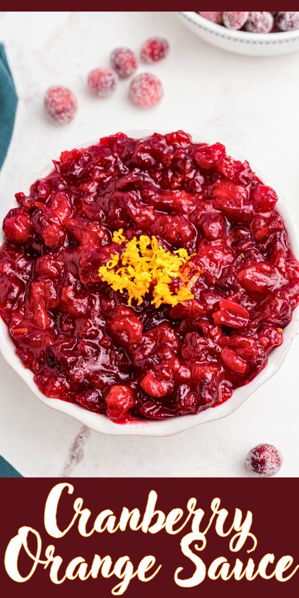 Bright red cranberry sauce in a white bowl, topped with orange zest as a garnish.