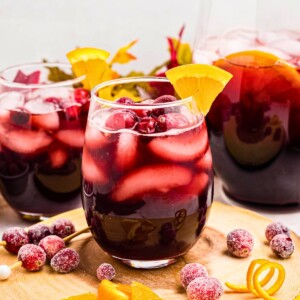 Sangria in a clear stemless glass with orange slice as a garnish.