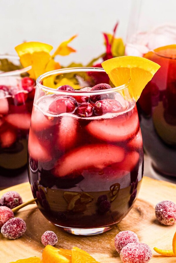 Sangria in a clear stemless glass with orange slice as a garnish.