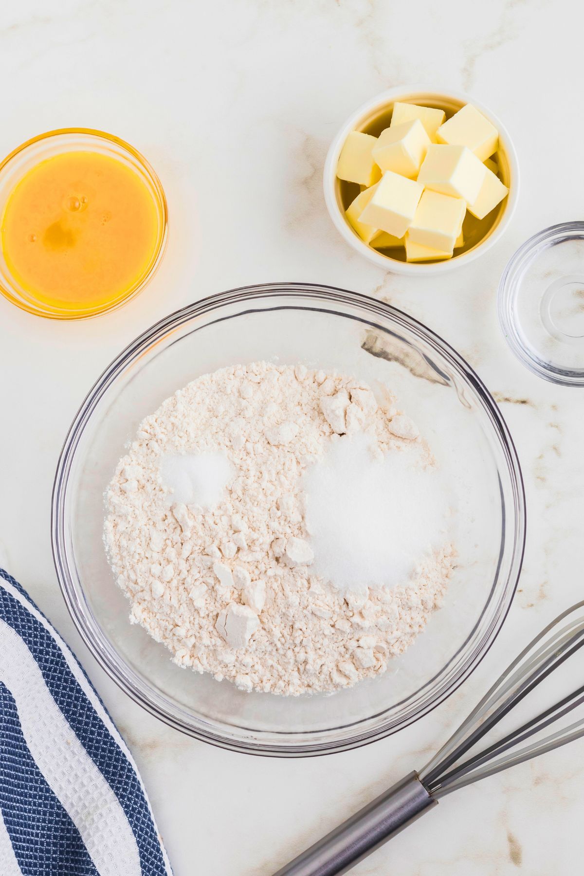 Dry ingredients mixed together in a large clear glass bowl. 