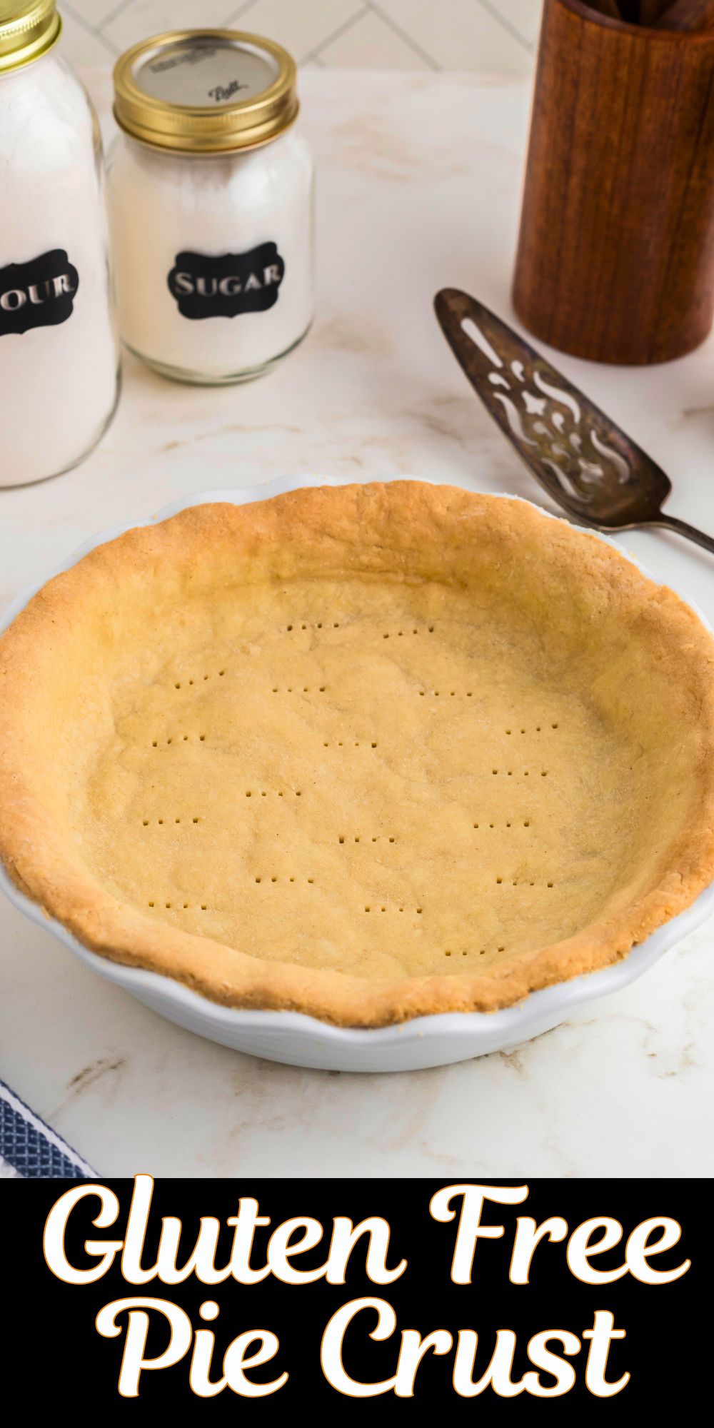 Golden brown baked pie crust in a white pie plate on a marble table.