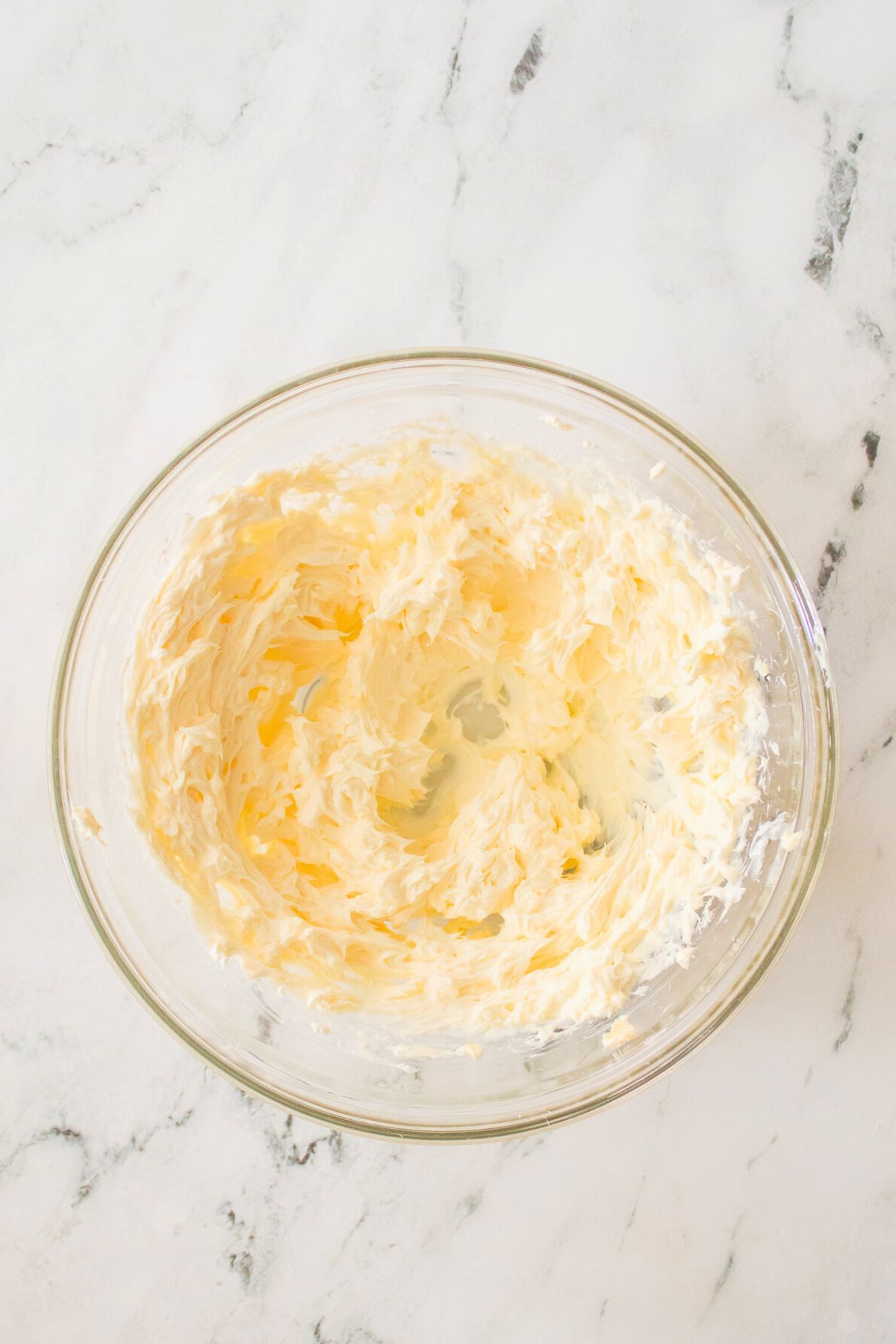 Butter and sugar creamed together in a clear bowl. 