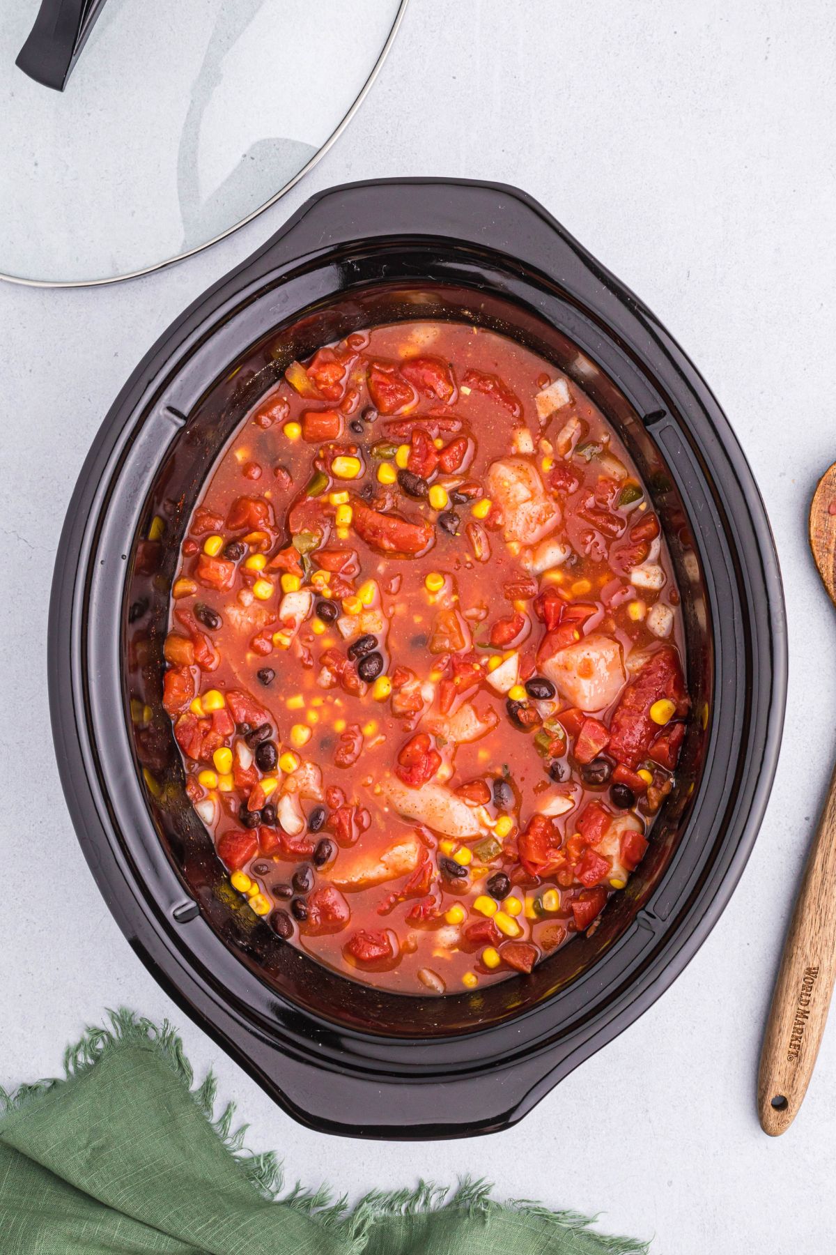 Ingredients for chili in a slow cooker pot after being stirred together. 