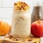 Creamy yogurt mixed with oats and apple slices in a mason jar making apple pie overnight oats.