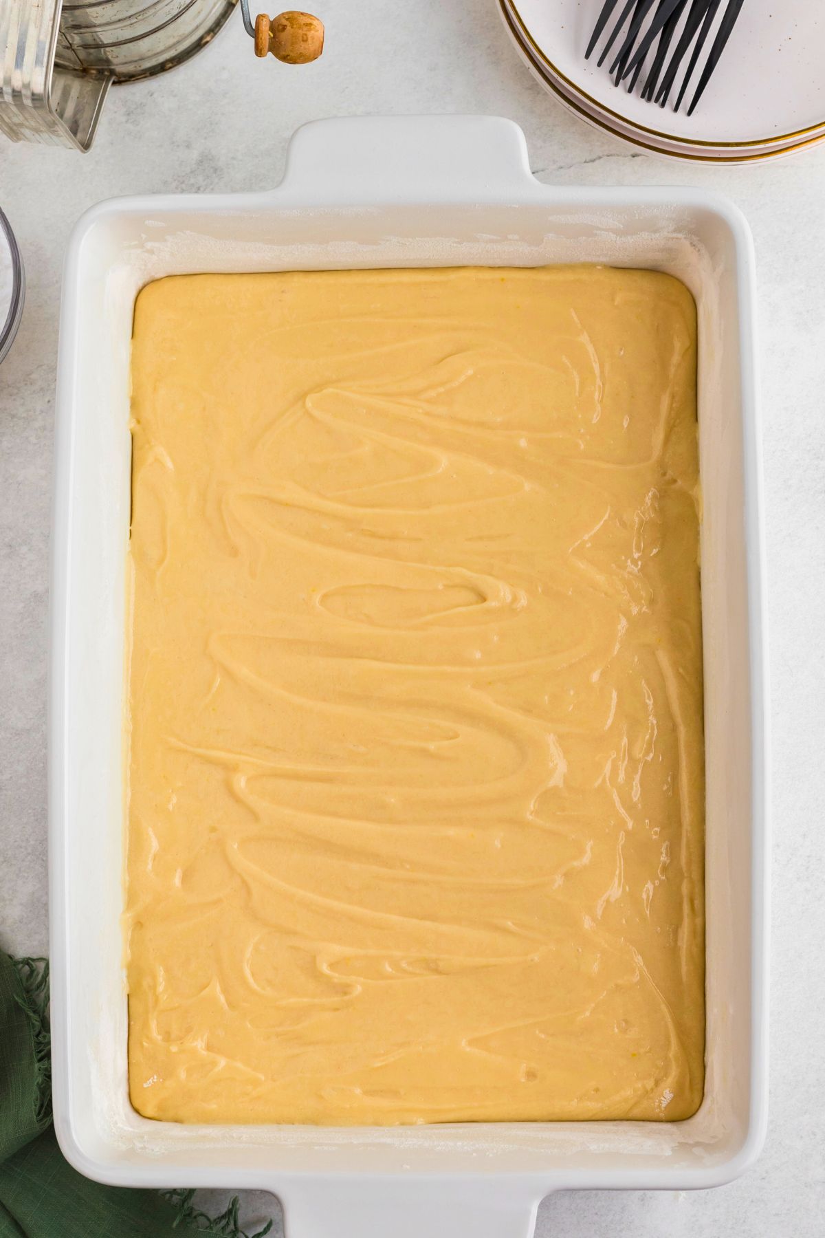 Uncooked cake batter spread evenly into a baking dish. 