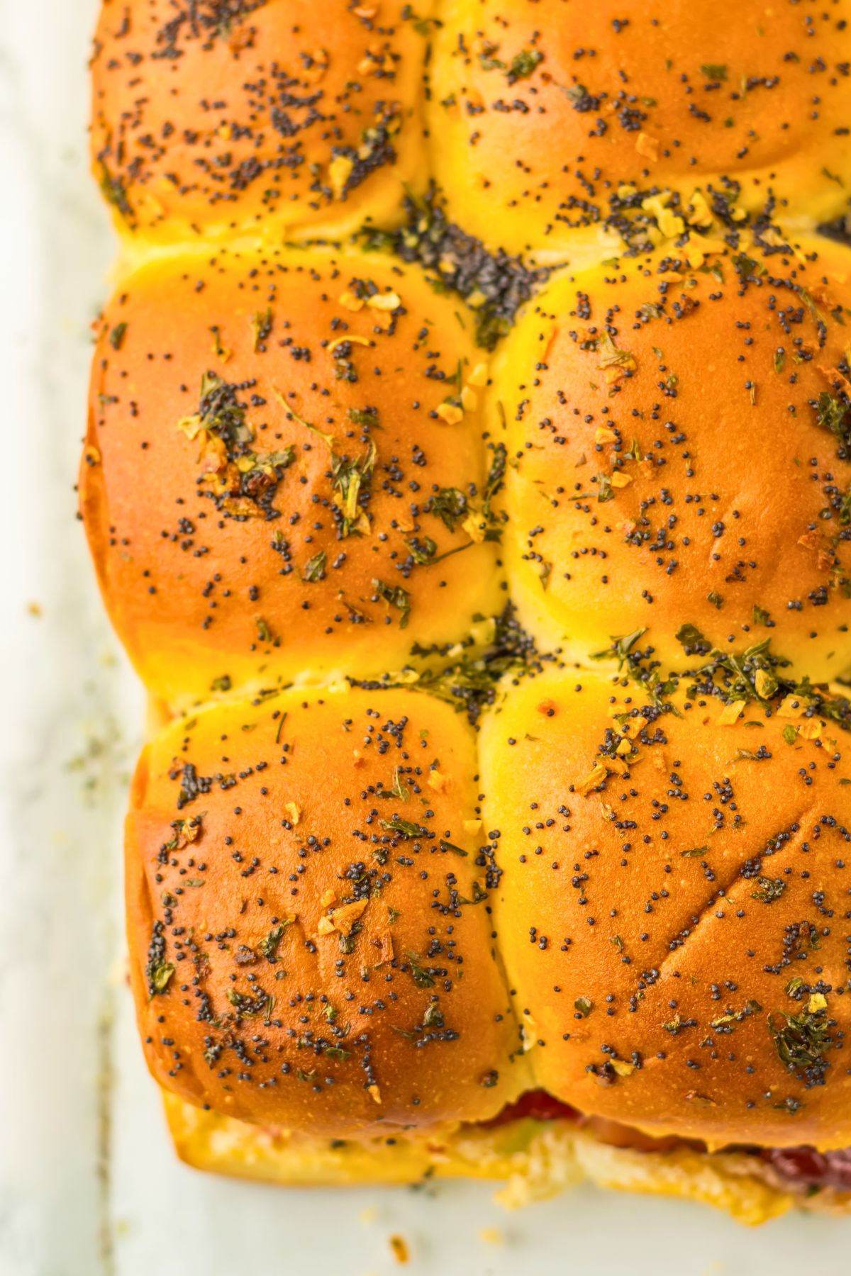 Cooked holiday sliders in a baking dish before slilcing. 