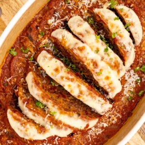 Italian meatloaf in an oval casserole dish, topped with mozzarella cheese and marinara sauce