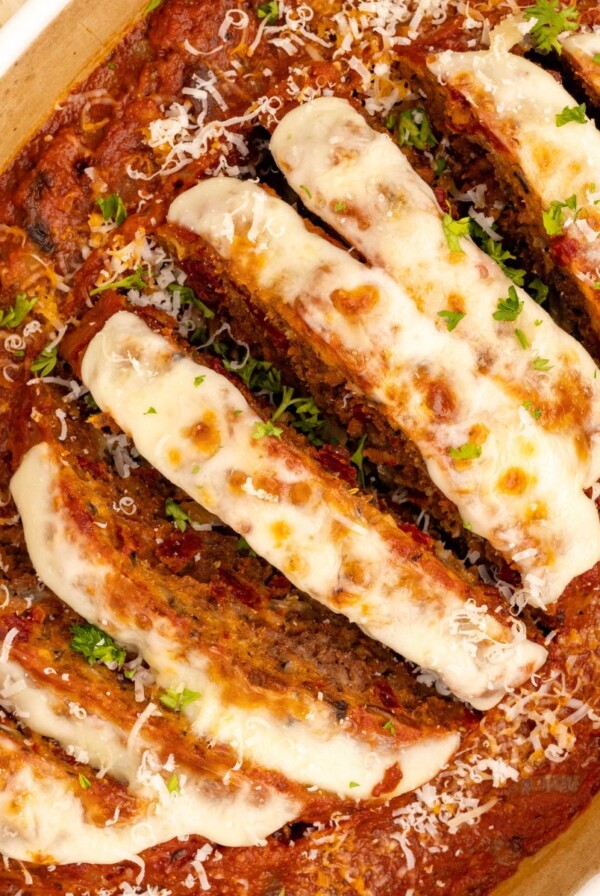 Italian meatloaf in an oval casserole dish, topped with mozzarella cheese and marinara sauce