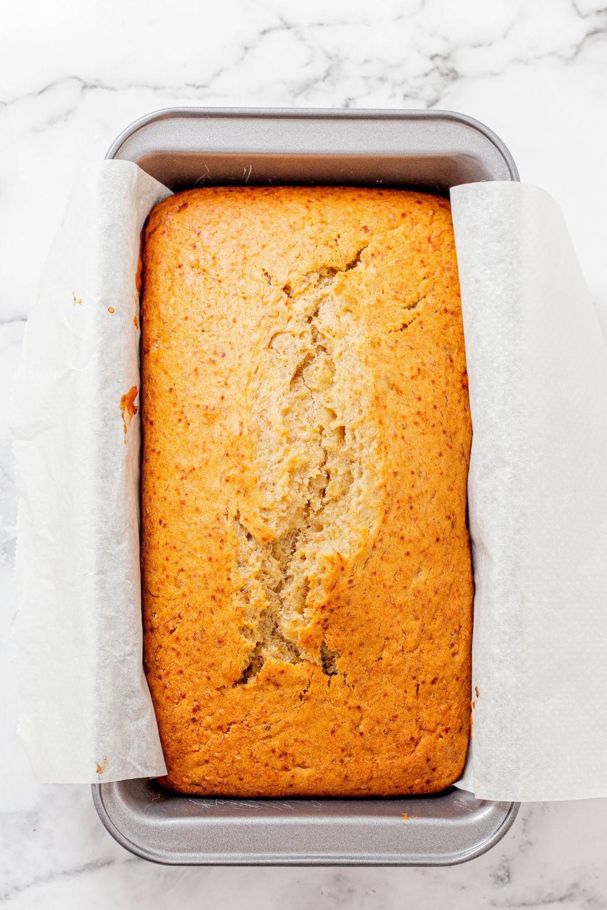 Golden loaf of banana bread after being baked