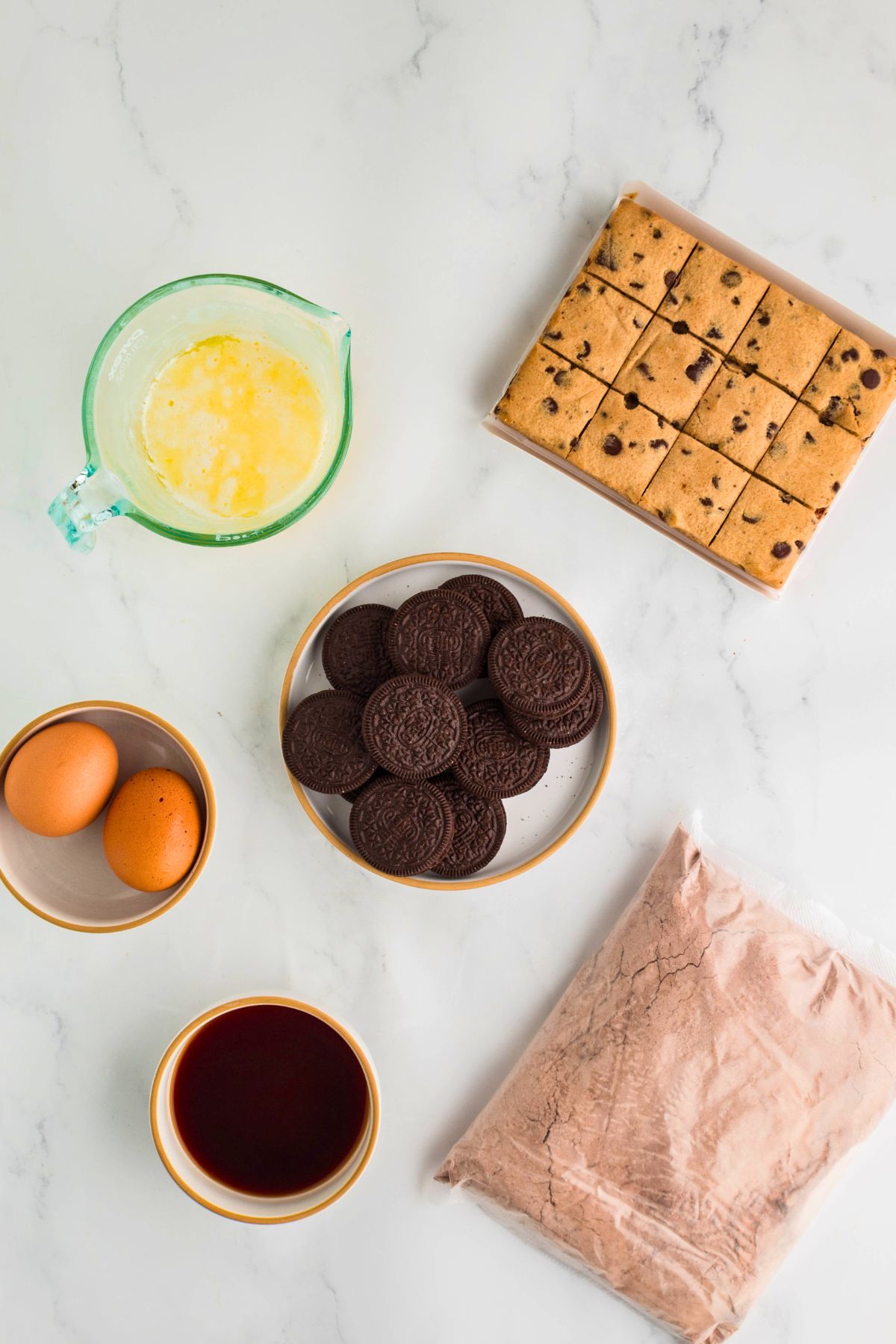 Ingredients needed to m make slutty brownies measured out on a marble table. 