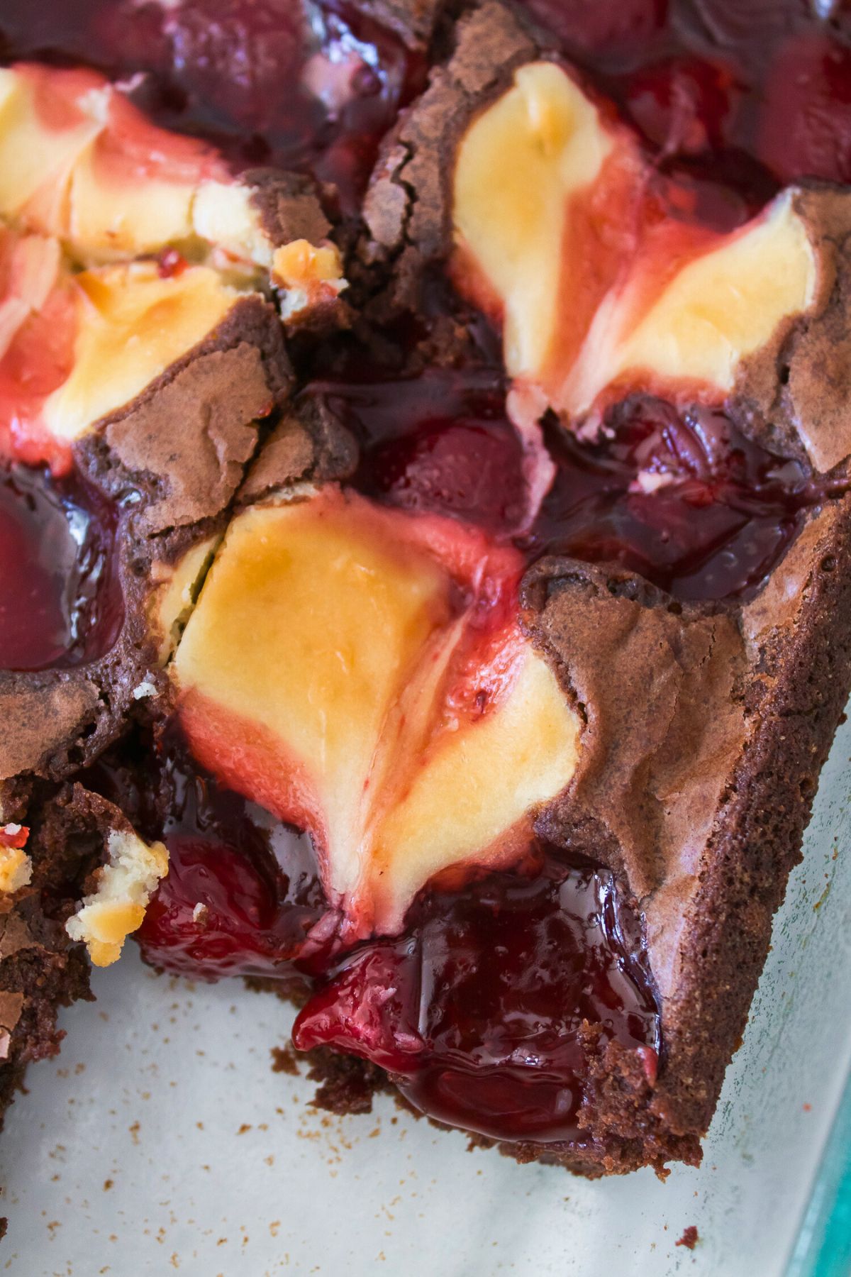 Creamy strawberry cheesecake brownies in a baking dish, cut into slices. 