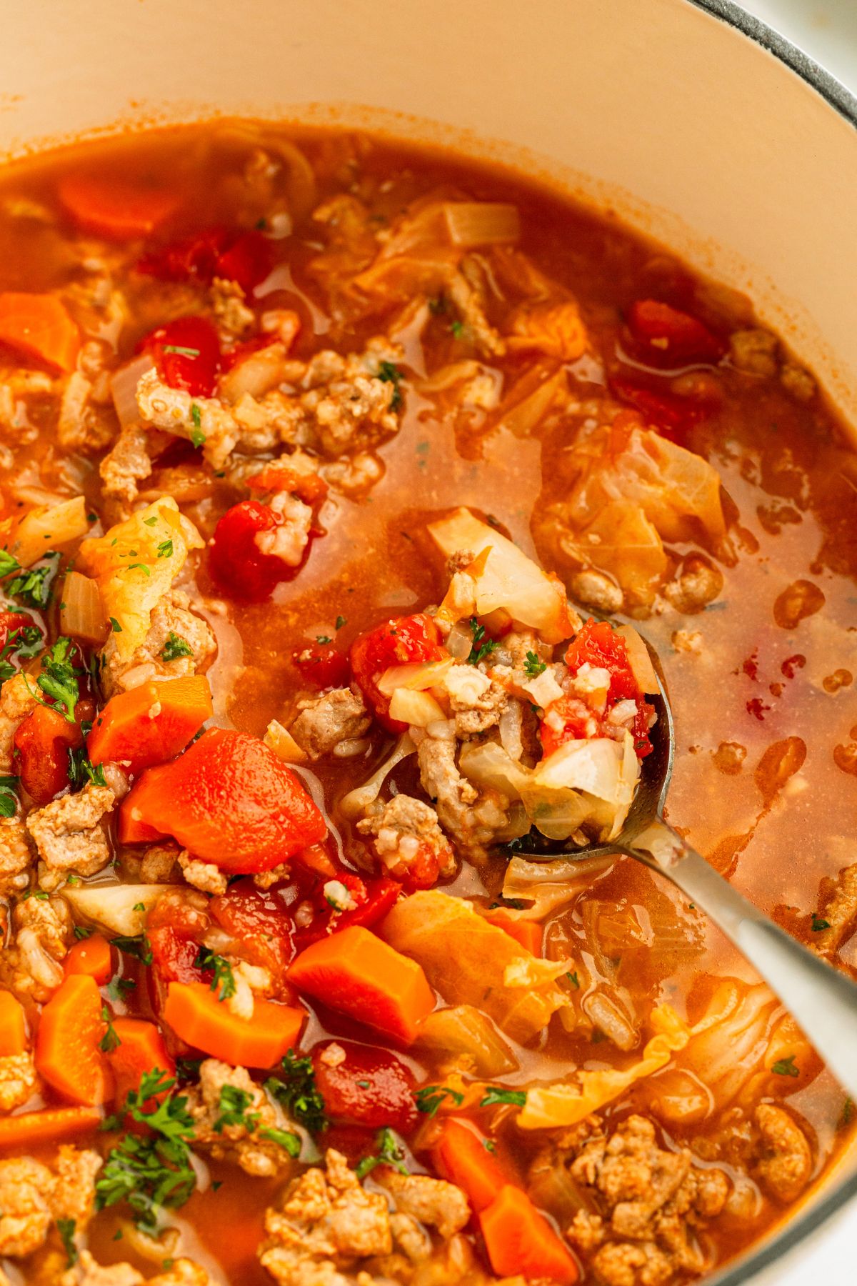 Soup being stirred and a spoonful lifted out of the stockpot. 